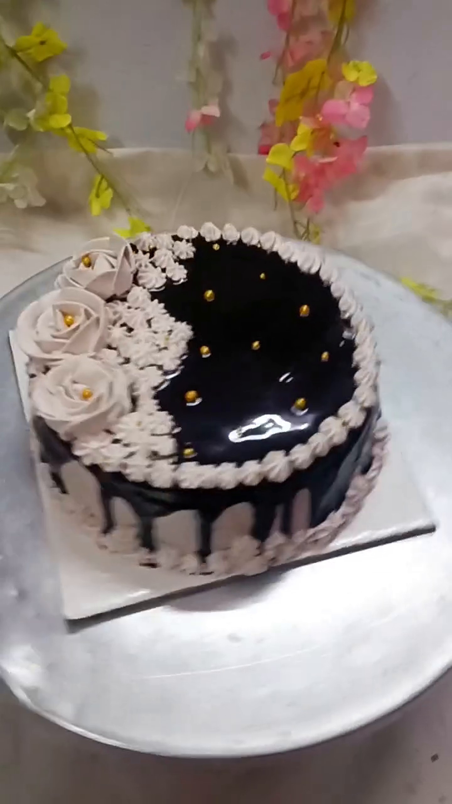 Midnight black drip cake with white buttercream flowers